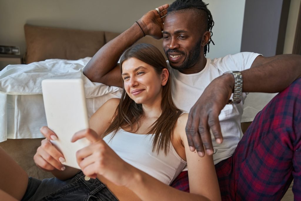 Happy couple watching something on tablet computer